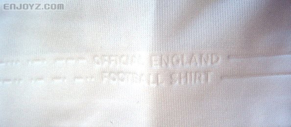 右袖口处的压纹：（ＯＦＦＩＣＩＡＬ　ＥＮＧＬＡＮＤ　ＦＯＯＴＢＡＬＬ　ＳＨＩＲＴ。“英格兰官方球衣”